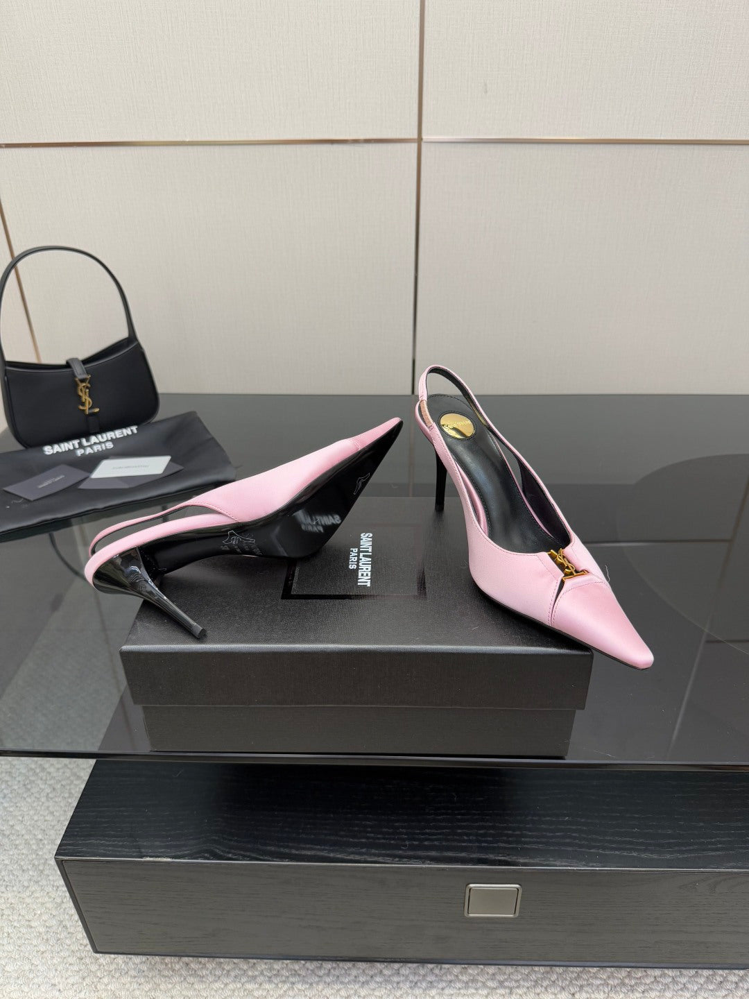 Pink slingback heels with pointed toe, black interior, and gold ankle-buckle detail