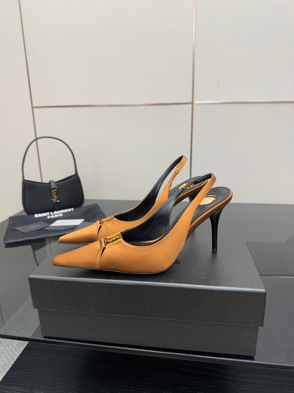 Orange pointed-toe slingback high heels with black heel lining and gold detail