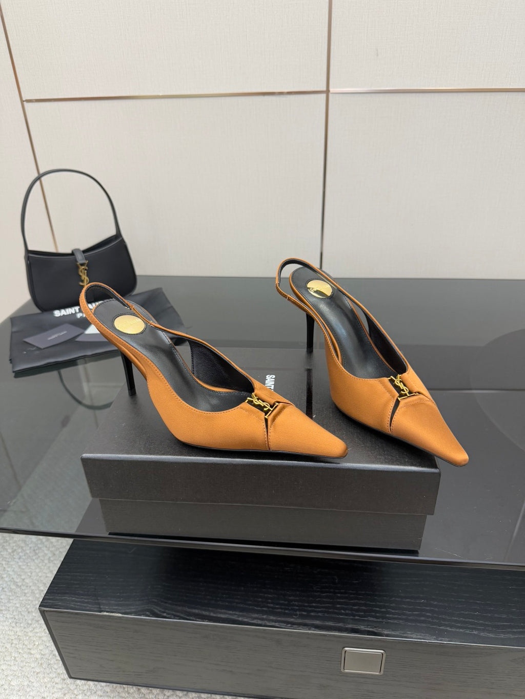 Orange and black slingback heels with pointed toe and gold logo detail
