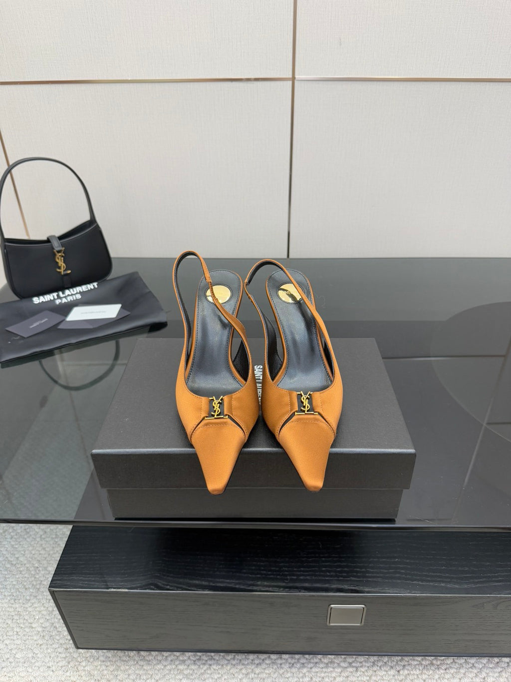Orange pointed-toe slingback heels with black insole and gold logo accent