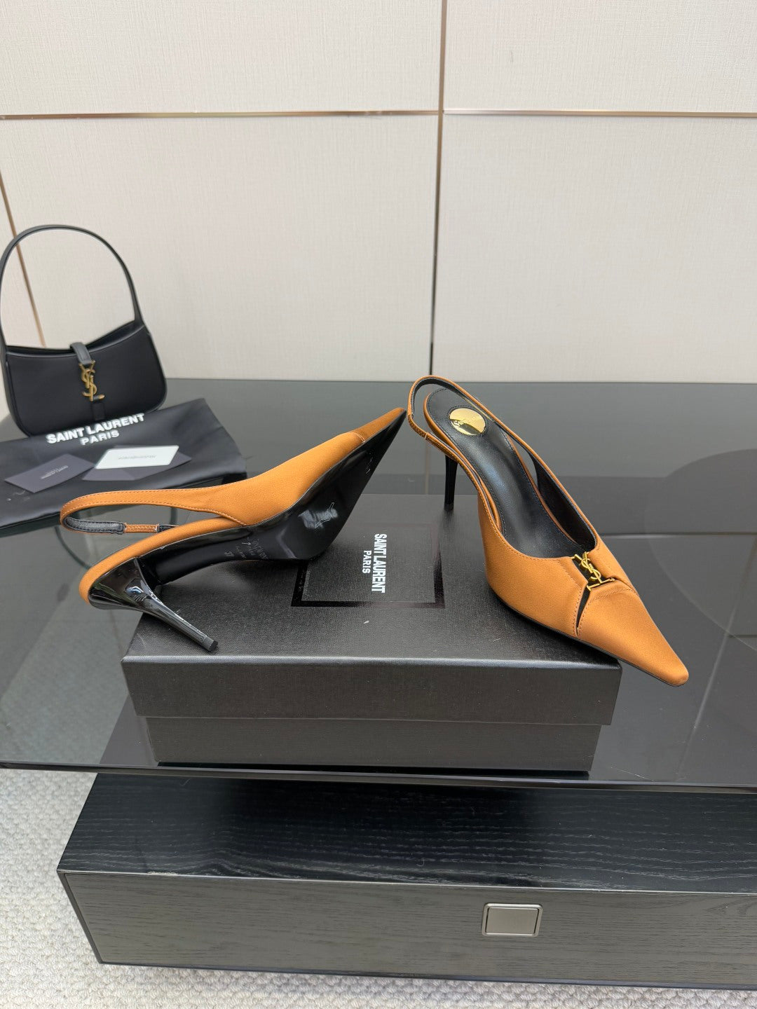 Orange slingback stiletto heels with pointed toe and gold logo hardware