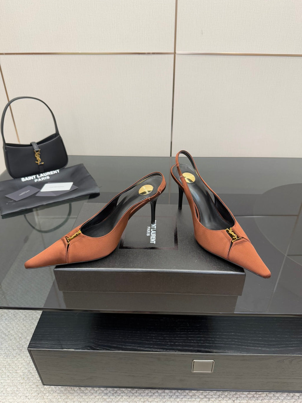 Tan slingback pumps with stiletto heels, gold buckle logo, pointed toe design