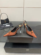Tan slingback pumps with stiletto heels, gold buckle logo, pointed toe design