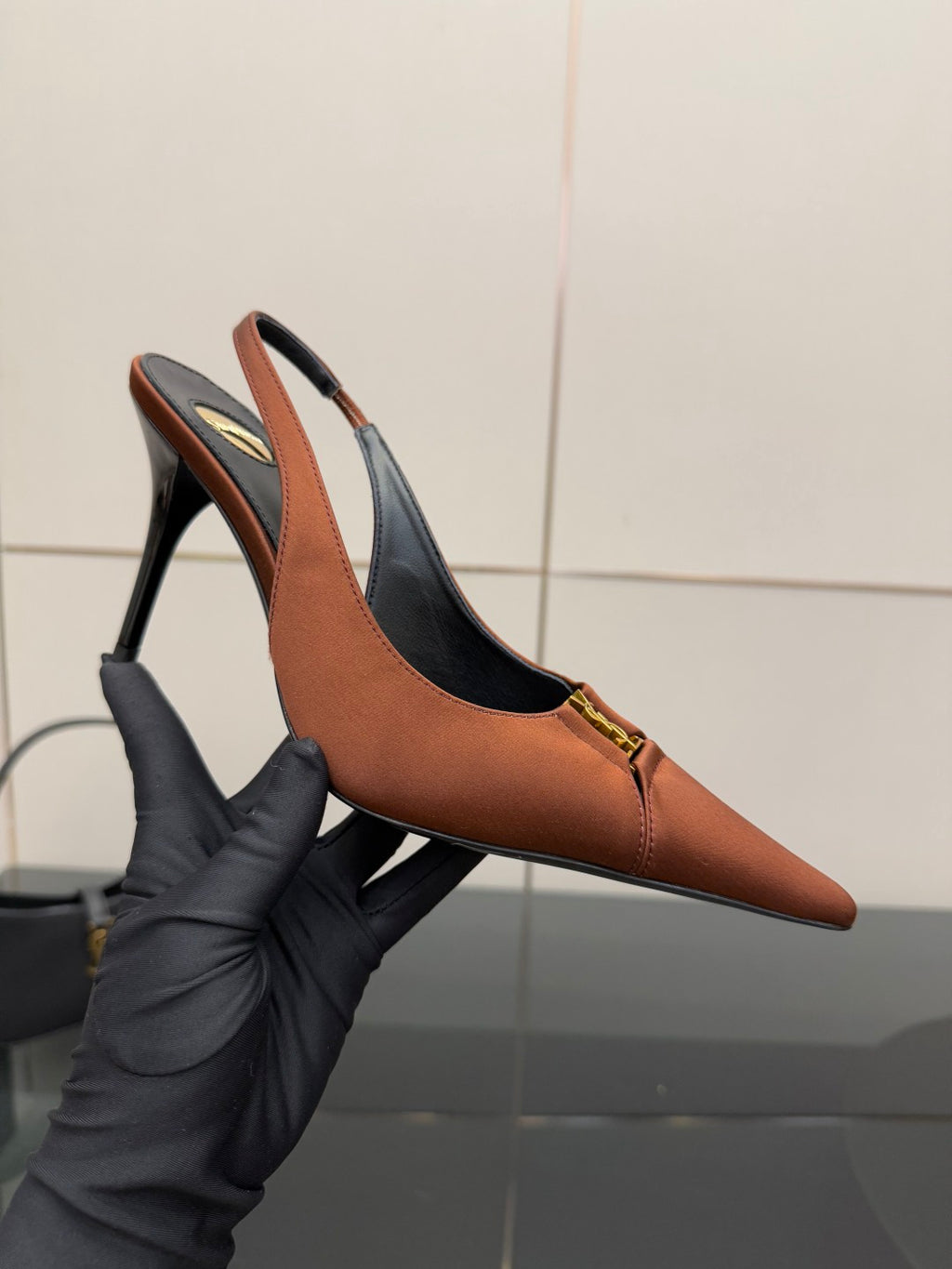 Tan pointed-toe slingback heel with thin stiletto, gold logo buckle on strap