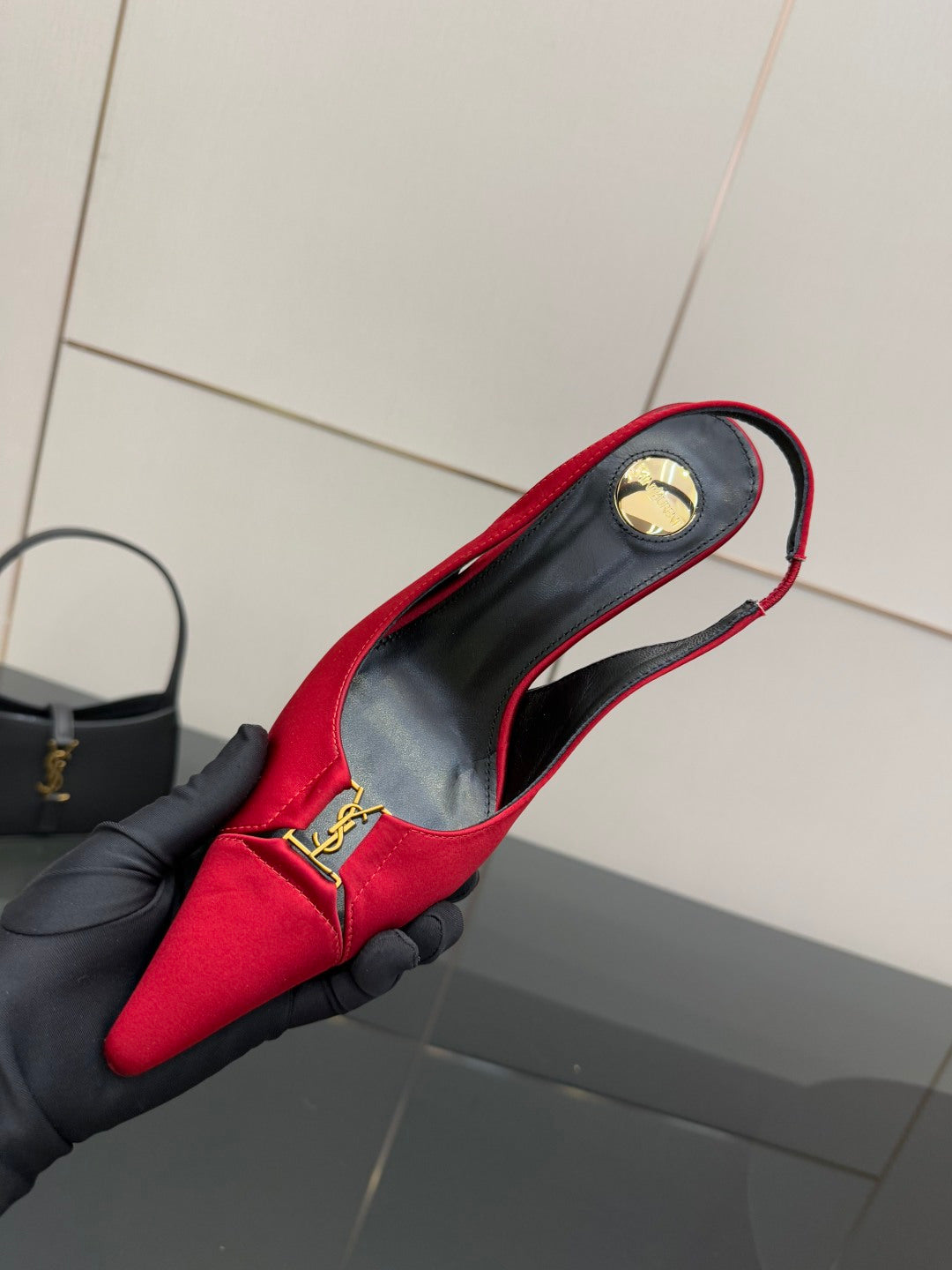 Women’s red slingback heel showing YSL round gold logo badge