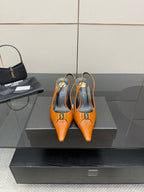Women's orange pointed-toe stiletto heels with gold buckle detail