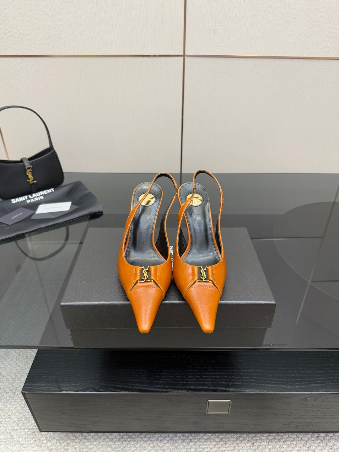 Women's orange pointed-toe stiletto heels with gold buckle detail