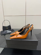 Women's orange pointed-toe stiletto heels, side view, gold buckle detail