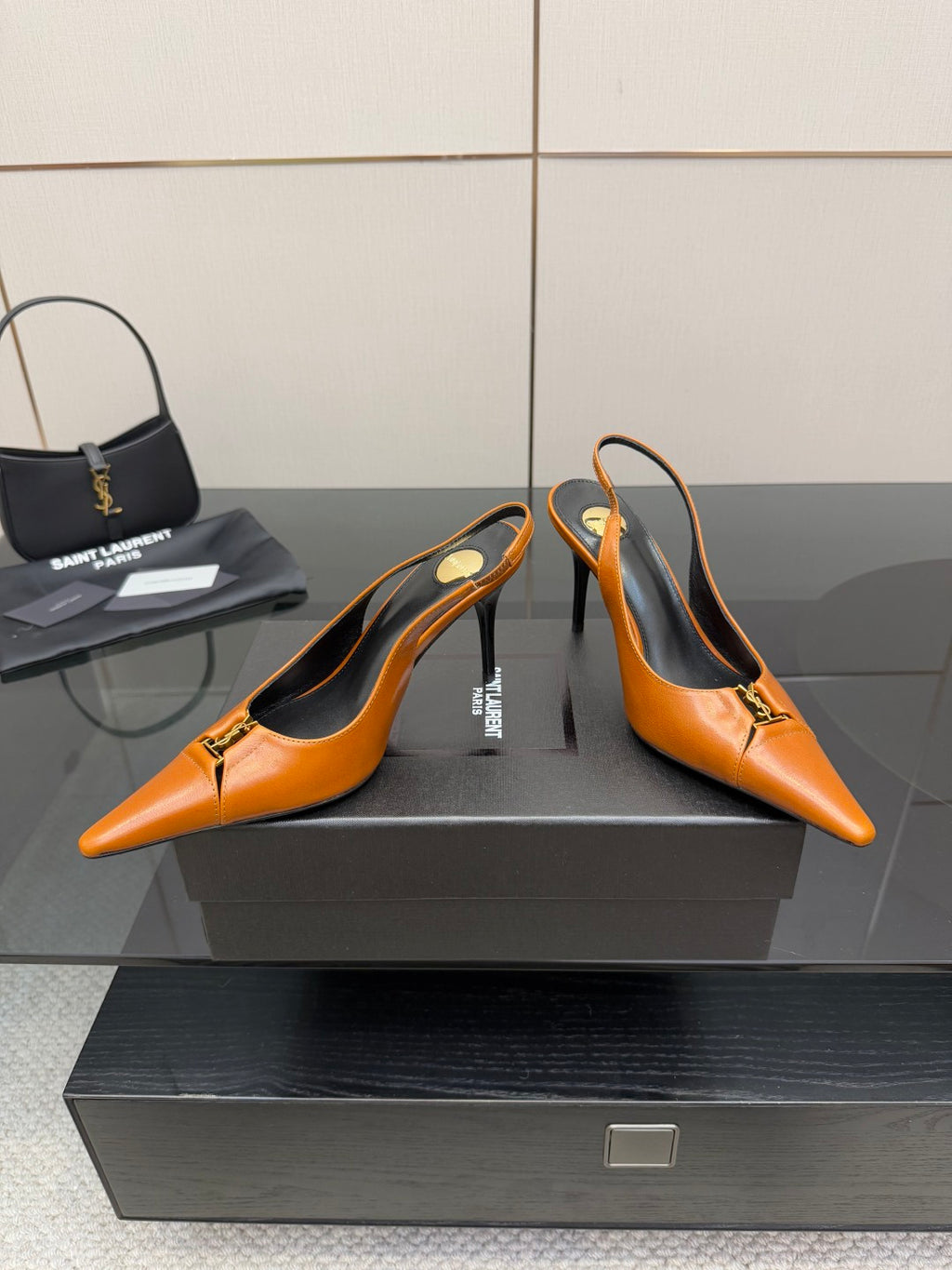 Women's orange pointed-toe stiletto heels, three-quarter view, gold buckle detail