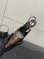 YSL ladies pointed-toe slingback heel held in hand, brown uppers, gold emblem
