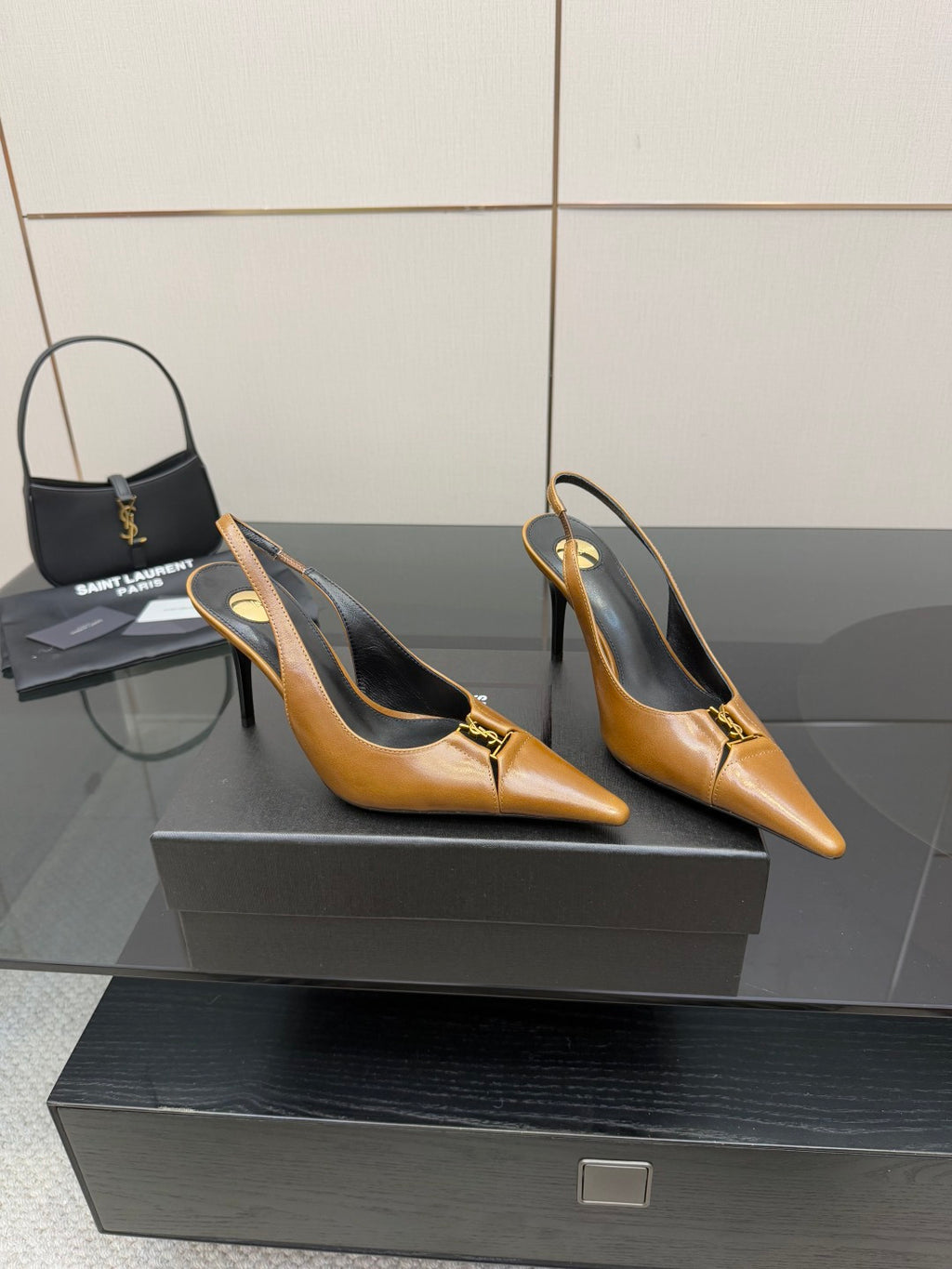 YSL ladies' tan pointed-toe high heels on a display platform, stiletto heel visible
