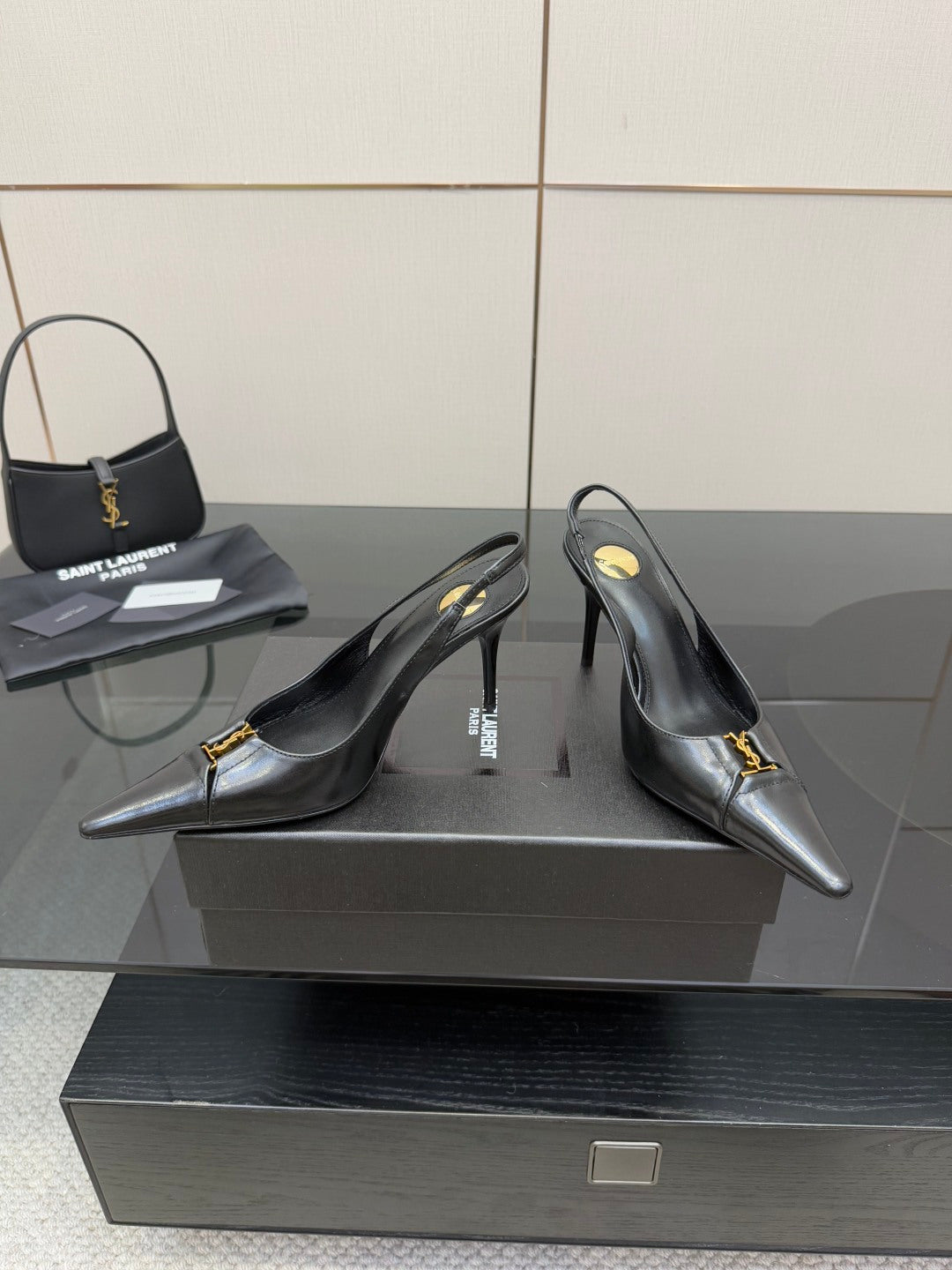 YSL ladies black high-heel pumps with gold logo strap at vamp