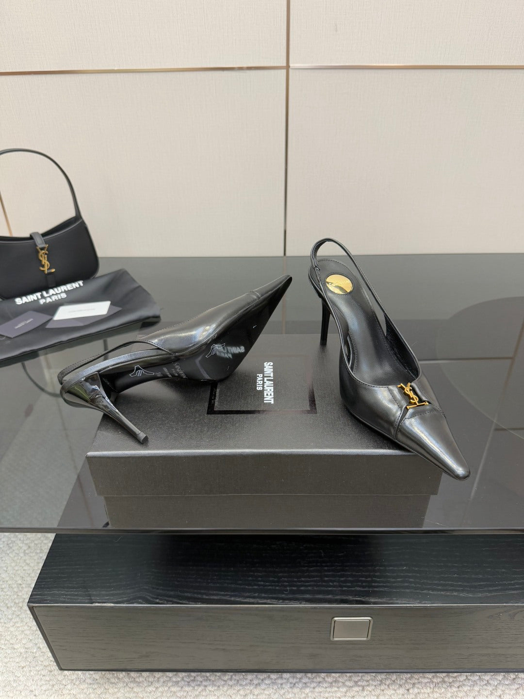 YSL ladies black pumps showing heel and side with gold logo strap