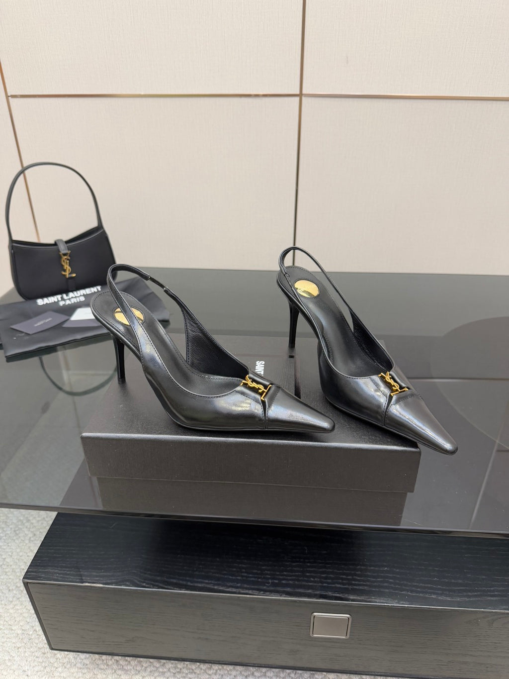 YSL ladies black pointed-toe pumps with gold logo buckle detail