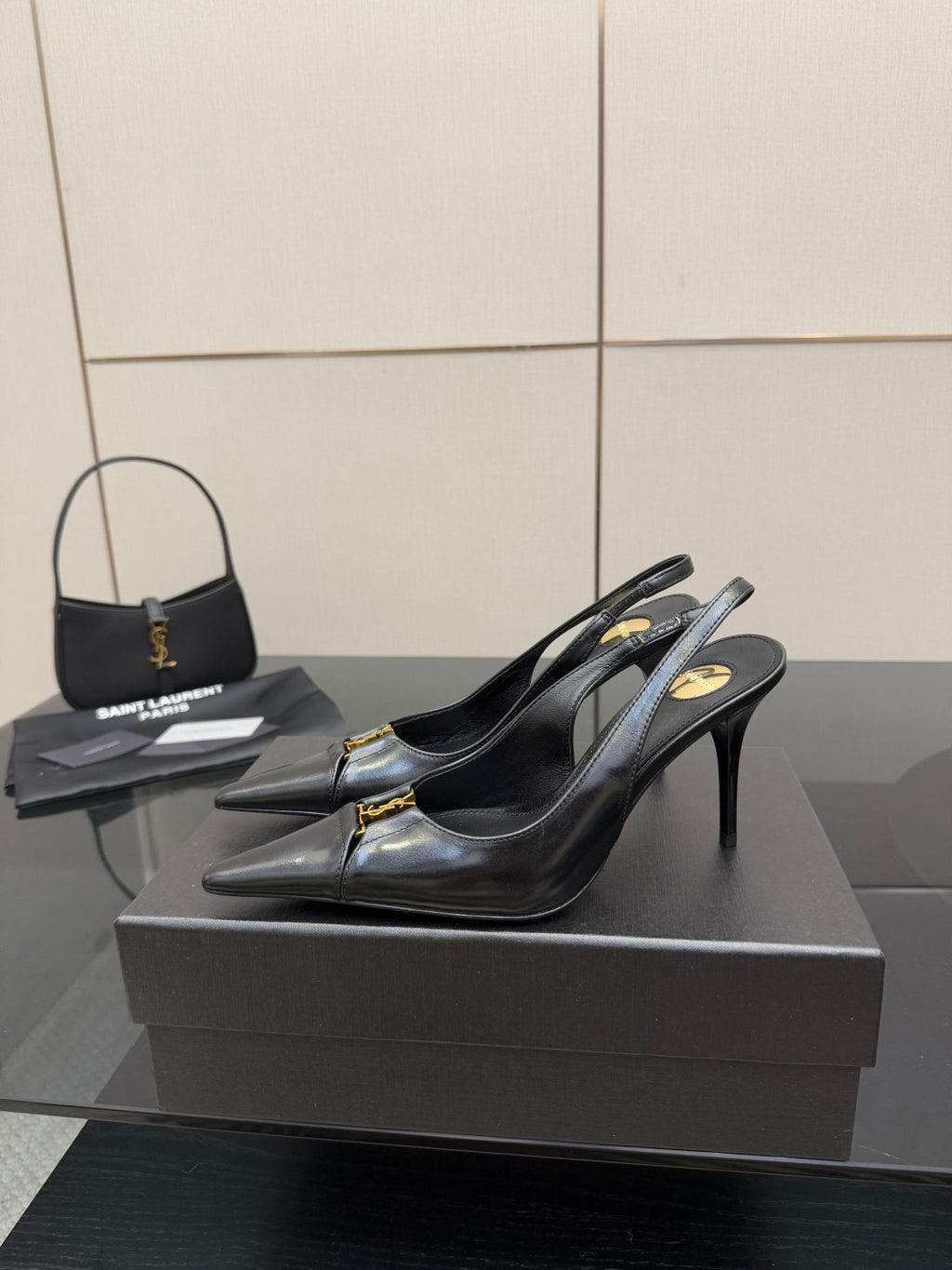 YSL ladies black slingback pumps on display with gold logo detail at toe