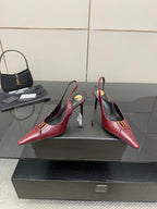 Burgundy red pointed-toe stiletto pumps with gold emblem, two-shoe view
