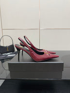 Burgundy red pointed-toe stiletto heel pair with ankle straps and gold emblem