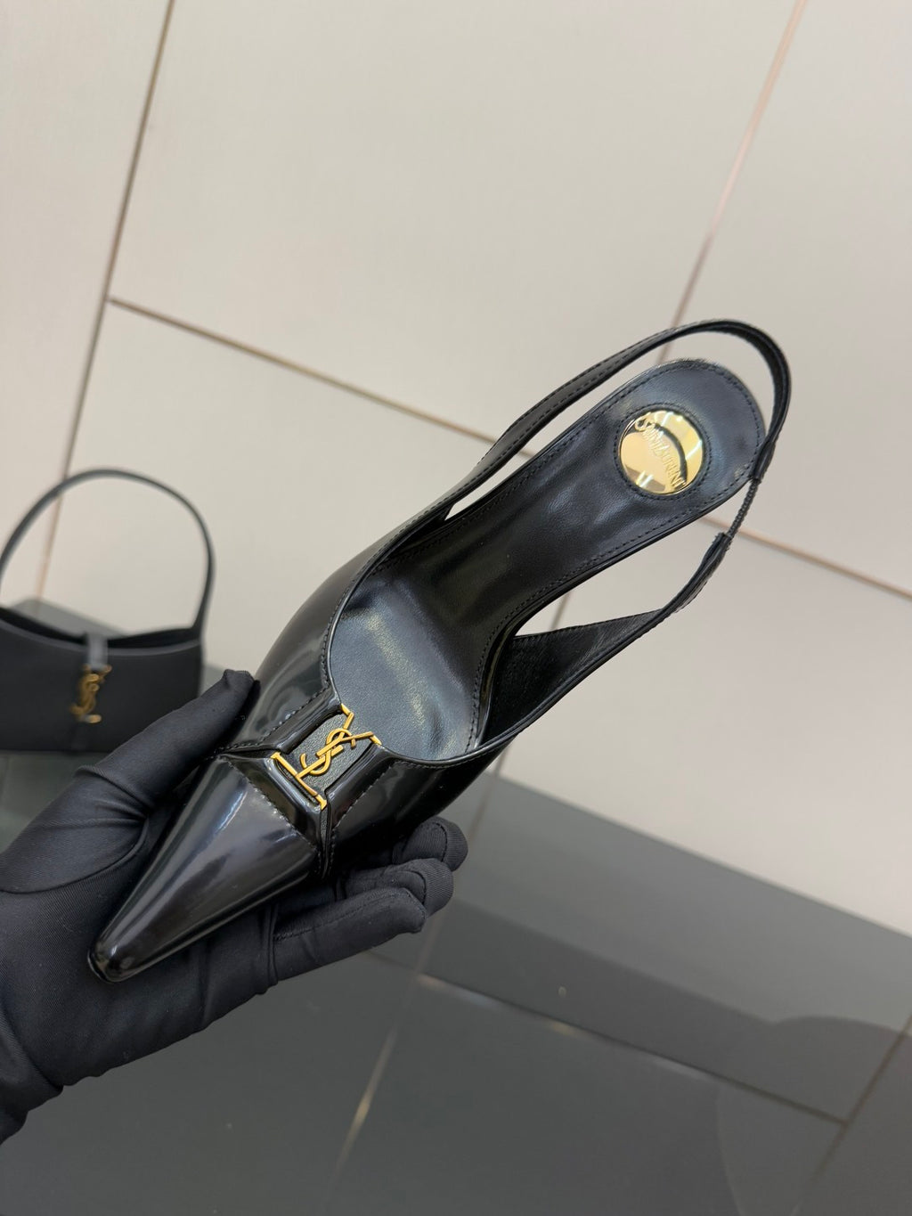 Black YSL slingback pump with heel strap and gold logo, pointed toe