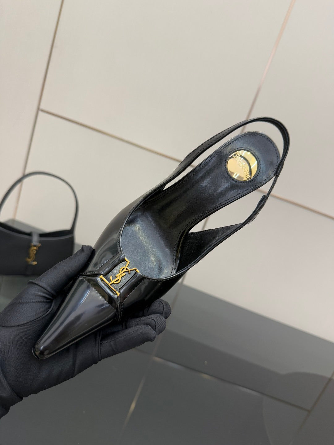 Black YSL slingback pump with heel strap and gold logo, pointed toe