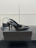 Black YSL slingback pump with pointed toe and tall stiletto heel, gold logo