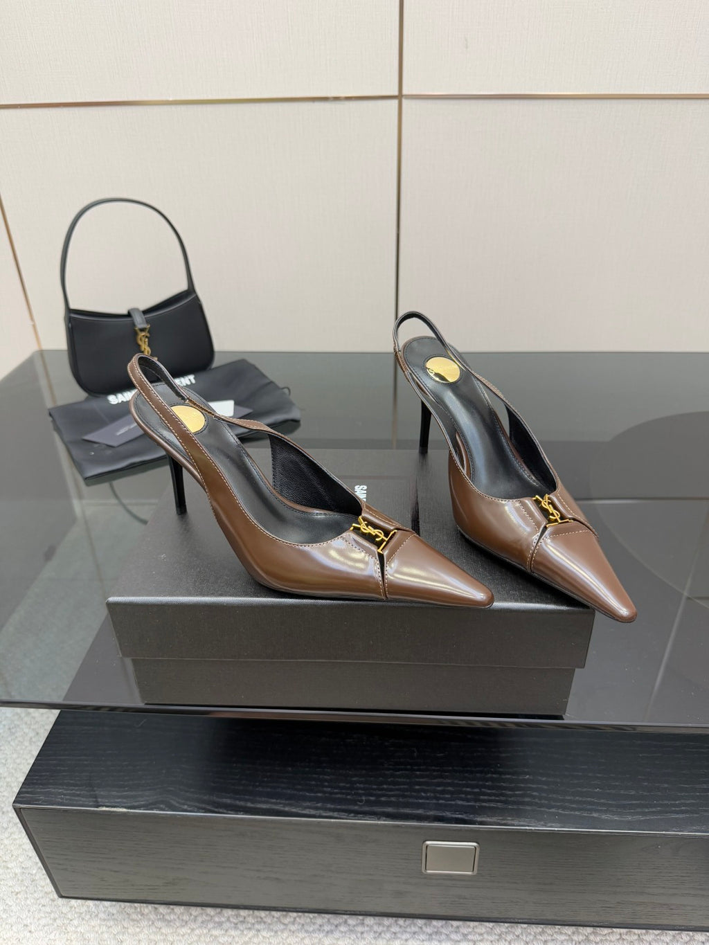 Pair of brown leather pointed-toe slingback heels with gold logo accents