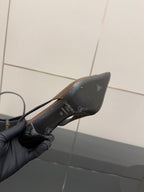 Brown pointed-toe pump showing black insole with printed logo and marks