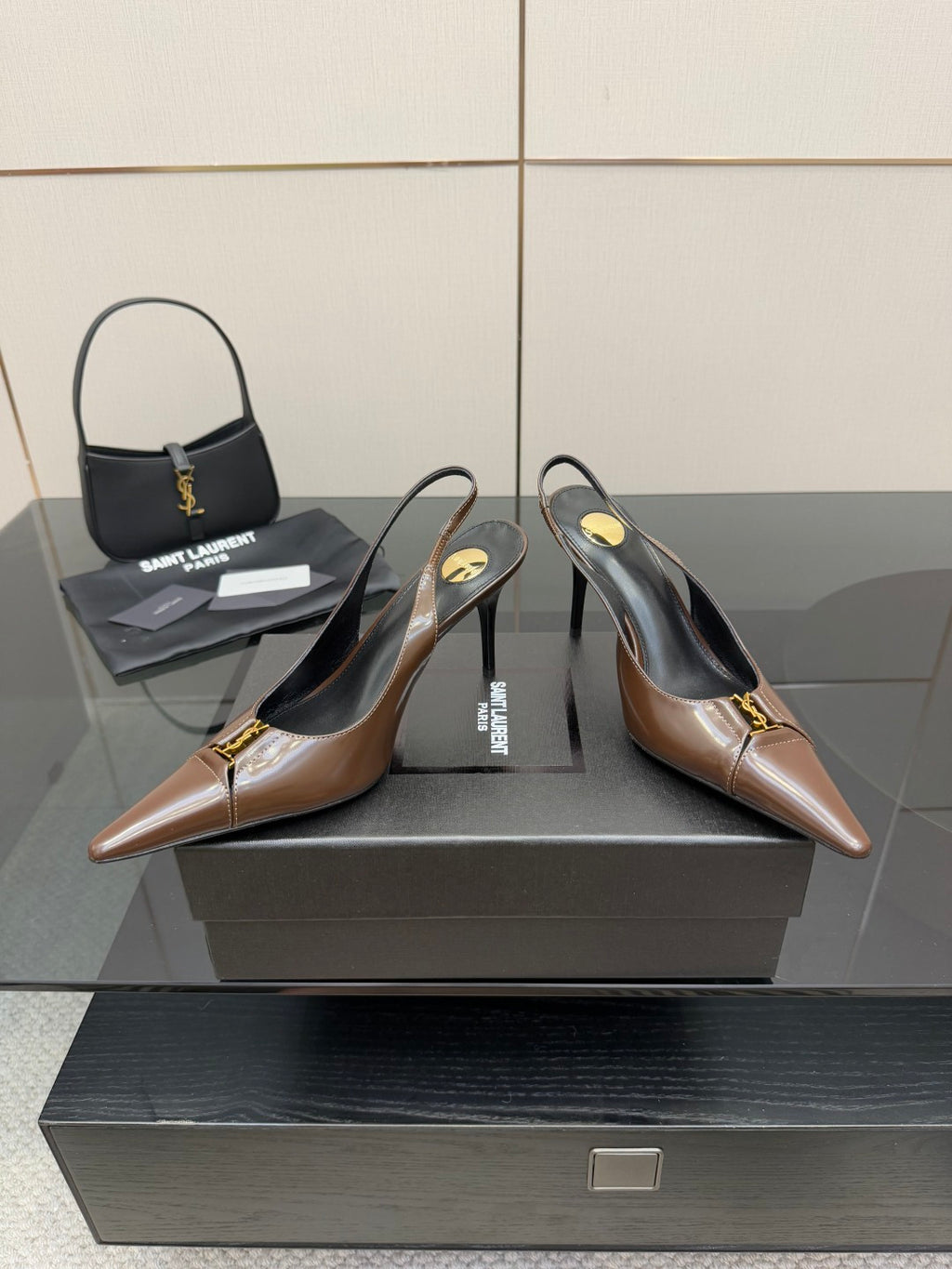 Brown leather slingback pumps with pointed toe and gold logo detail