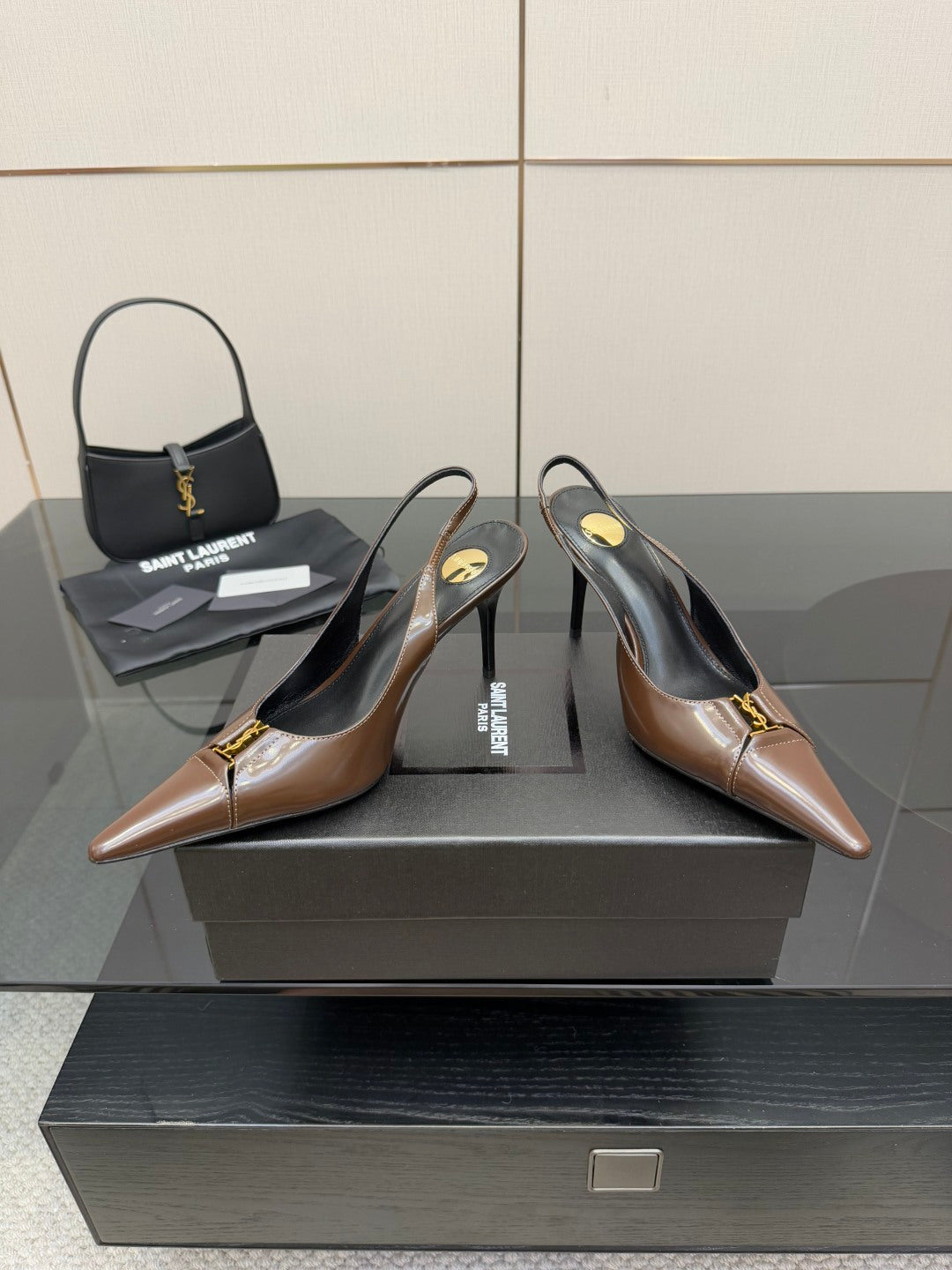 Brown leather slingback pumps with pointed toe and gold logo detail