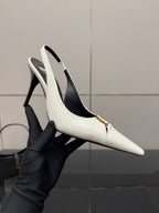 White pointed-toe slingback stiletto heel shoe held in a black glove, gold logo detail.