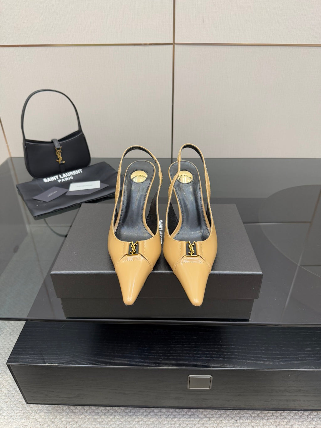 YSL beige patent slingback heels with pointed toe and stiletto heel on display