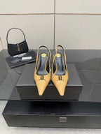 YSL beige patent slingback heels with pointed toe and stiletto heel on display