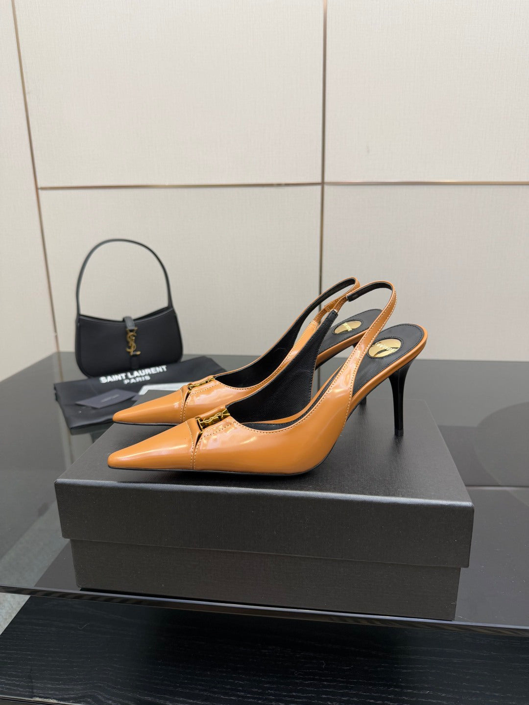 Women’s orange pointed-toe slingback pumps on a black display box, stiletto heel