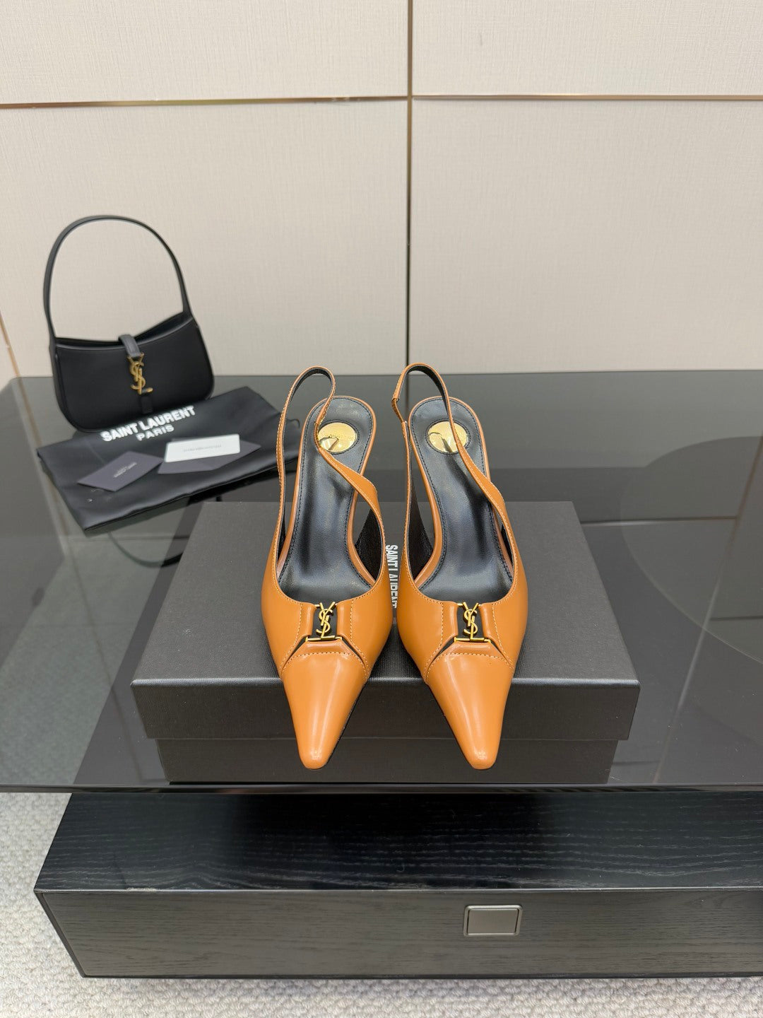 Women’s orange pointed-toe slingback pumps with stiletto heels and gold logo detail