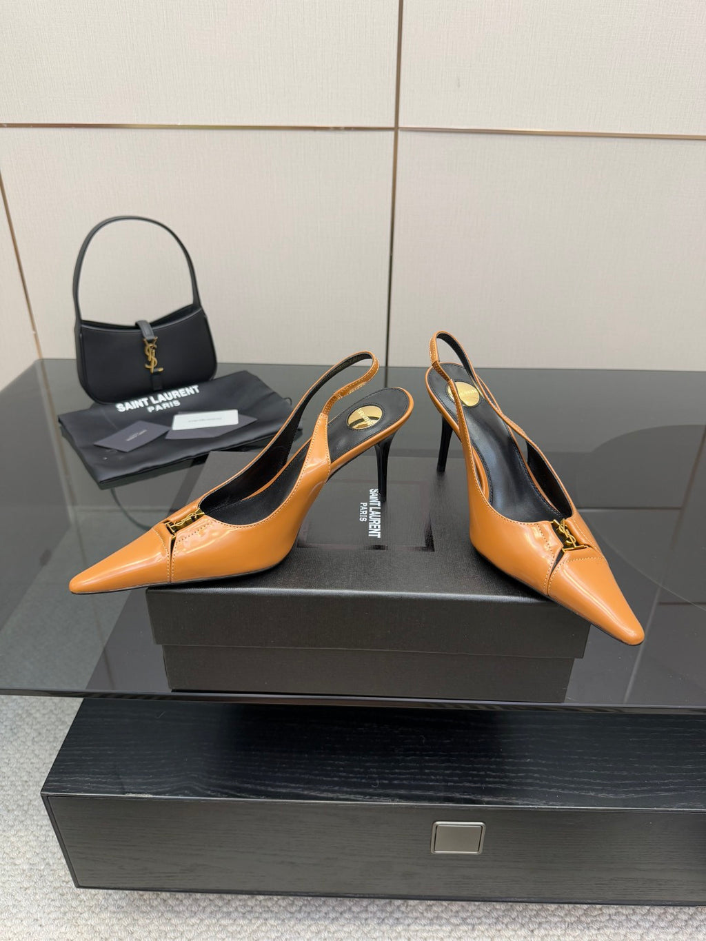 Women’s orange pointed-toe slingback pumps with stiletto heels and logo accent