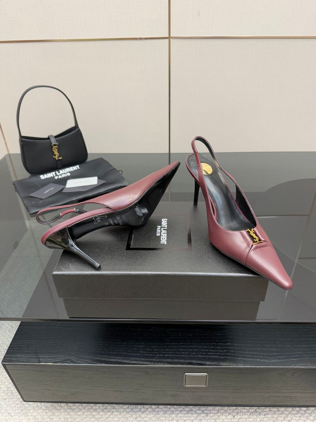 Burgundy slingback pointed-toe high heels with gold logo ornament, heel view