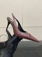 Burgundy pointed-toe slingback heel shown in gloved hand, gold logo detail