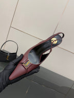Burgundy pointed-toe slingback heel close-up with gold logo on vamp