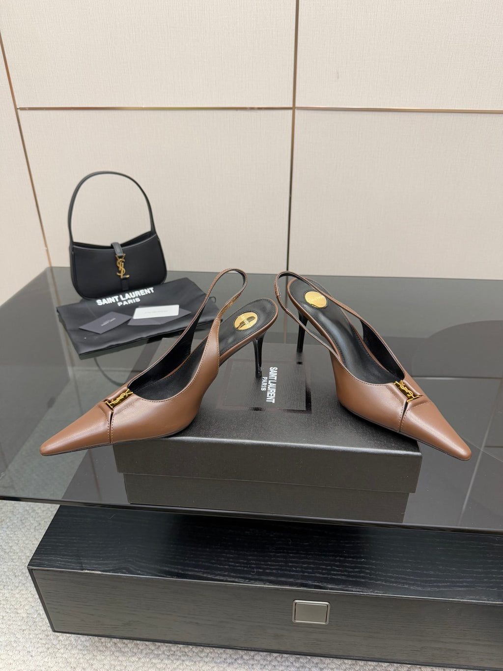 Brown pointed-toe slingback pumps with high heels and gold-tone hardware