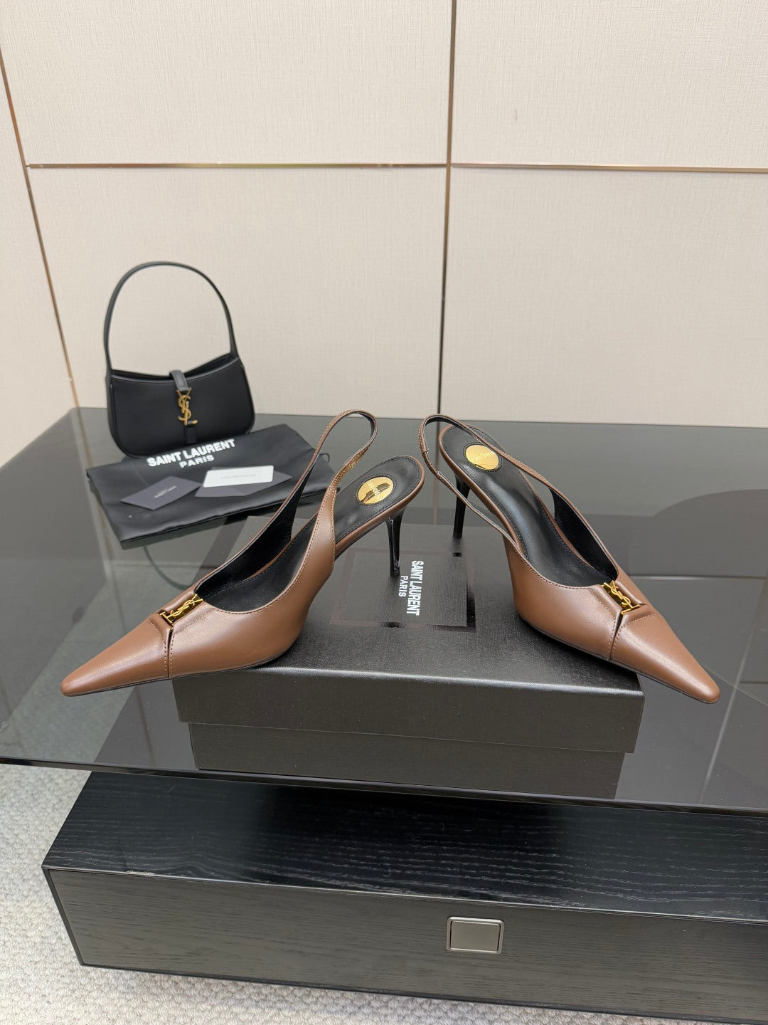 Brown pointed-toe slingback pumps with high heels and gold-tone hardware