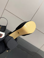 Black velvet platform sandal with light beige footbed underside view