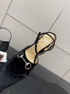 Black velvet sandal heel with ankle strap and silver ring hardware close-up