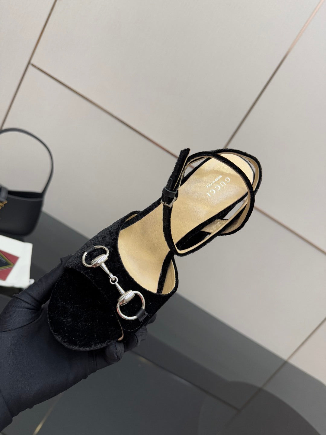 Black velvet sandal heel with ankle strap and silver ring hardware close-up