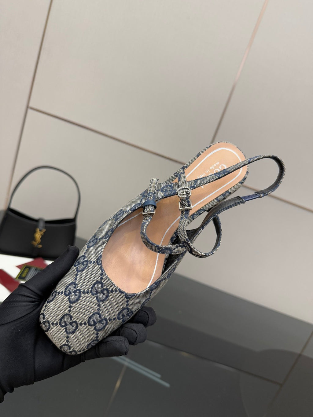 Close-up of blue GG monogram slingback flats with bow buckle