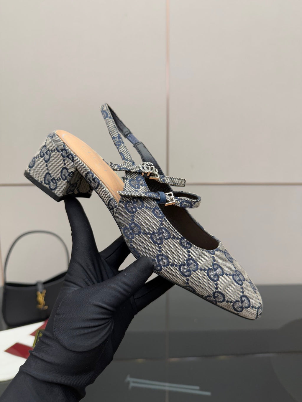 Close-up: blue GG monogram flats with bow buckle and slingback strap