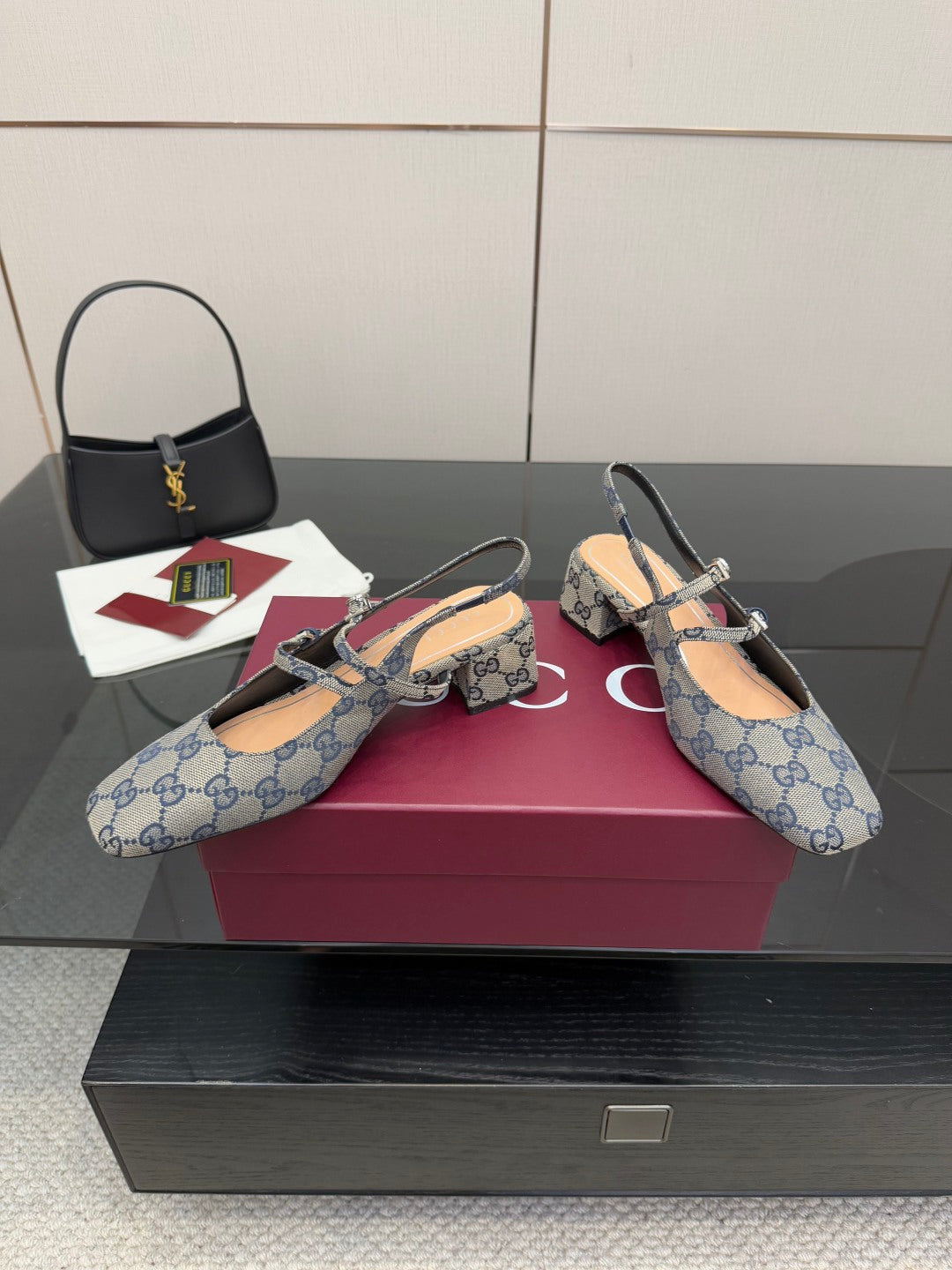 Two blue GG monogram flats with bow buckle and slingback strap, angled view