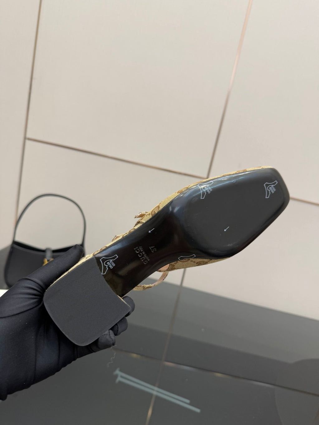 Gucci heeled mule outsole view with black sole and gold branding