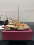 Gucci GG-pattern heeled mule showing side straps and small block heel