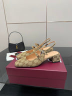 Gucci GG-pattern heeled mule with crisscross strap and gold-toned hardware