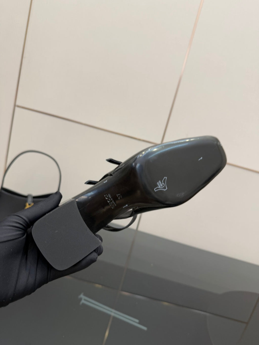 Black patent heel sole with small logo, underside view