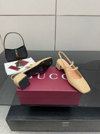 Beige patent leather slingback pumps with ankle strap and low block heel